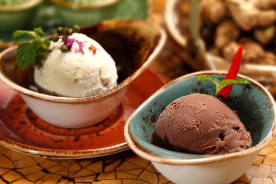 Scoops of vanilla and chocolate ice cream in small decorative bowls