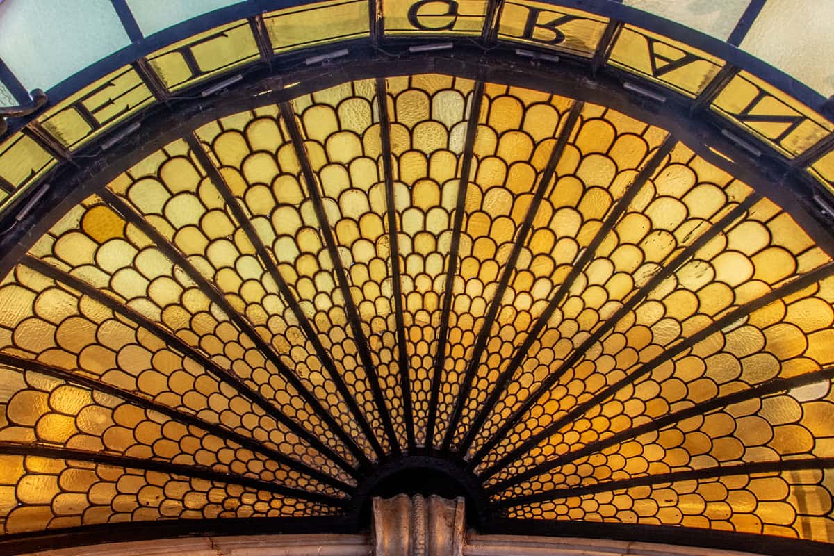 An amber stained-glass window with a geometric fan pattern